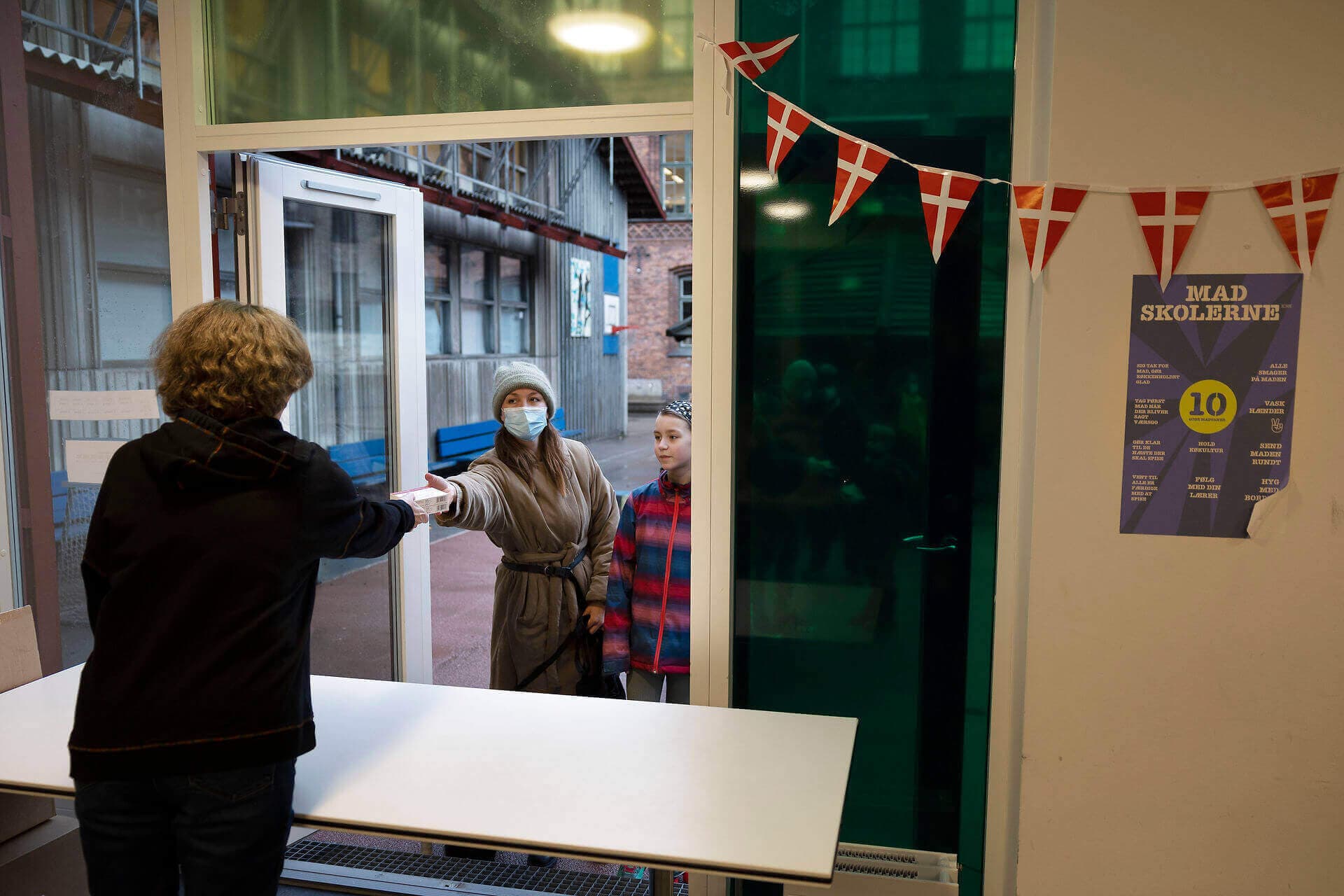 En mor henter hjemmetest-kit på Gasværksvejens Skole, Vesterbro, selv om børnene også kan blive testet på skolen. Håndteringen og styringen af coronaindsatserne har varieret fra kommune til kommune, viser forskningsprojekt fra SDU.